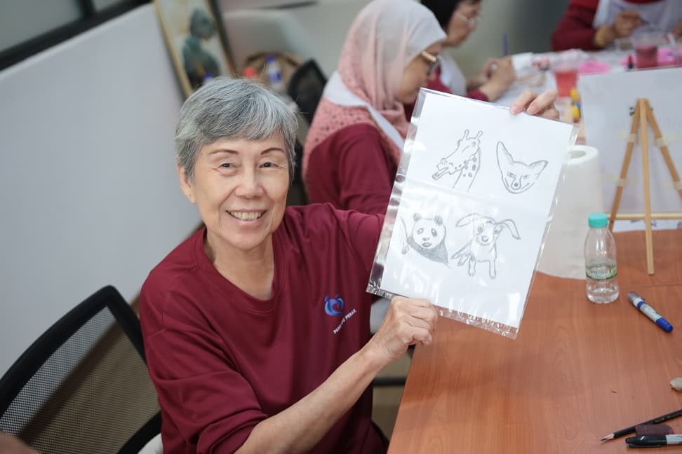 A participant showing the animal caricatures she drew during the session
