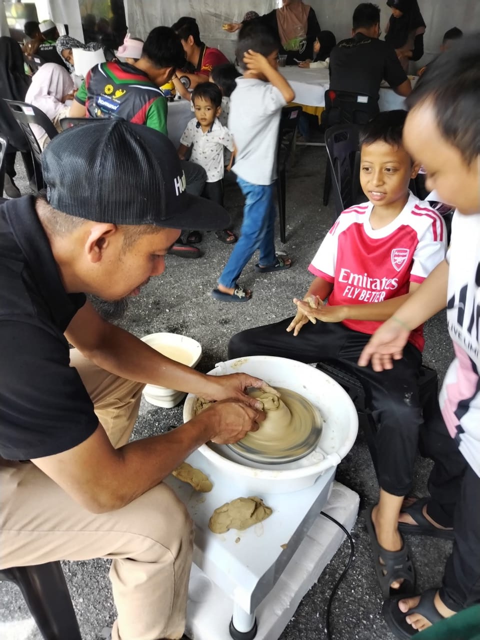 Visitors at the Ruang Karya ceramic painting booth during a children's literary and arts festival